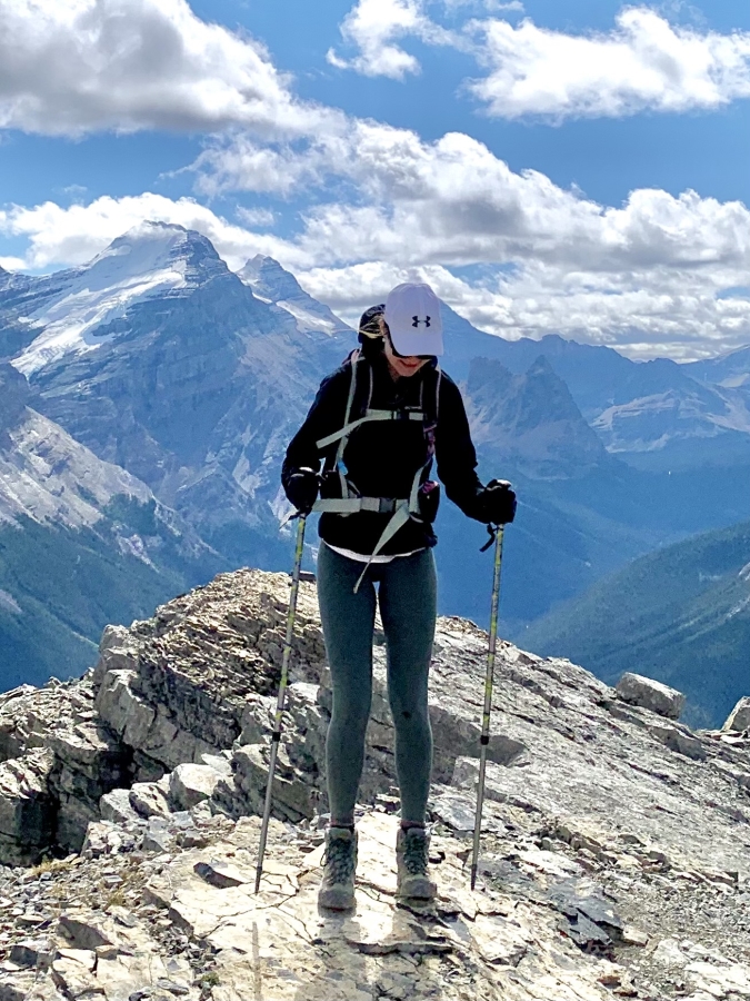 A Girl in Hiking Clothes with Trekking Poles Walks in the